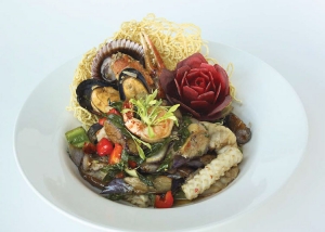 Fruits de mer et aubergines sautés sur un nid de nouilles croustillantes